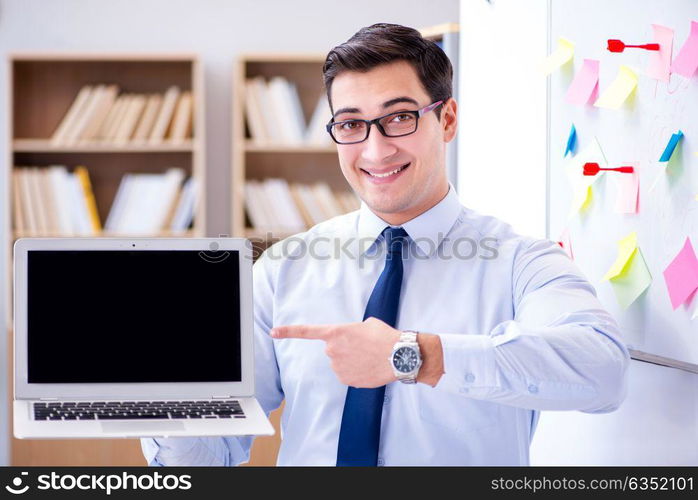 Young businessman demonstrating the screen of his laptop