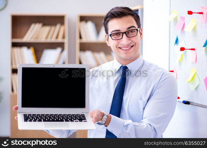 Young businessman demonstrating the screen of his laptop