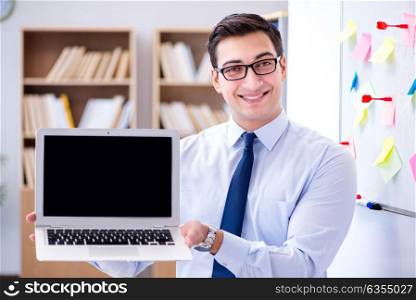 Young businessman demonstrating the screen of his laptop