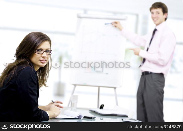 Young businessman doing presentation on whiteboard.