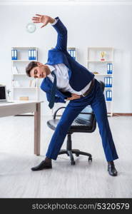 Young businessman doing sports stretching at workplace