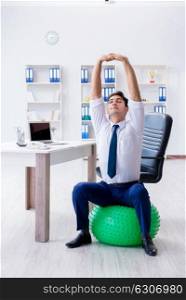 Young businessman doing sports stretching at workplace