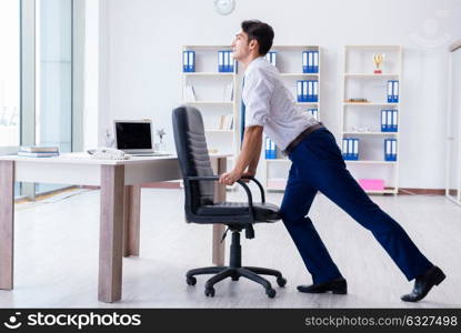 Young businessman doing sports stretching at workplace