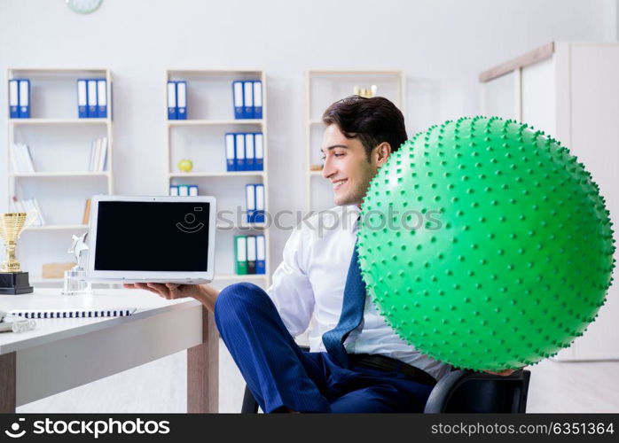 Young businessman doing sports stretching at workplace