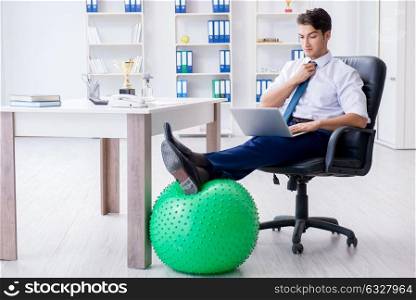 Young businessman doing sports stretching at workplace. The young businessman doing sports stretching at workplace