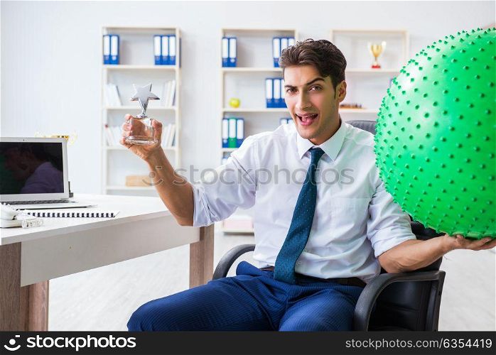 Young businessman doing sports stretching at workplace. The young businessman doing sports stretching at workplace