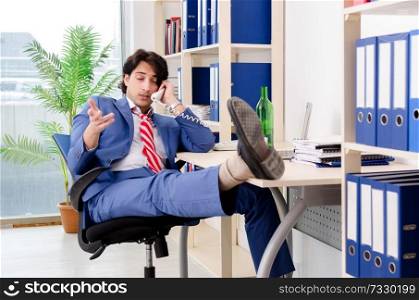 Young businessman employee drinking in the office