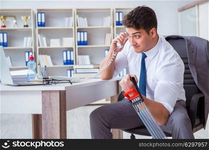 Young businessman exercising with elastic expander in office
