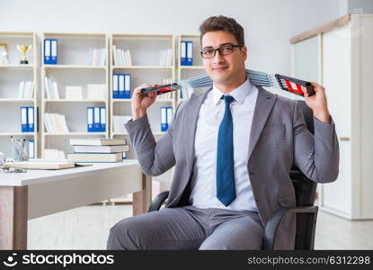 Young businessman exercising with elastic expander in office. The young businessman exercising with elastic expander in office