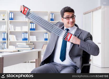 Young businessman exercising with elastic expander in office