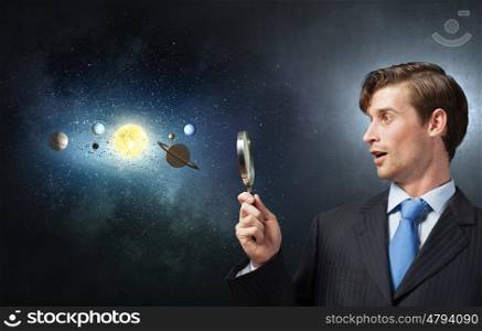 Young businessman exploring planets of sun system. Mysteries of space