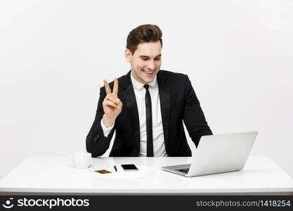 Young businessman facetime with someone and showing two finger or victory finger sign.. Young businessman facetime with someone and showing two finger or victory finger sign