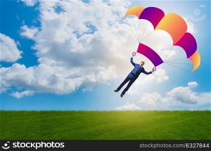 Young businessman falling on parachute in business concept. The young businessman falling on parachute in business concept