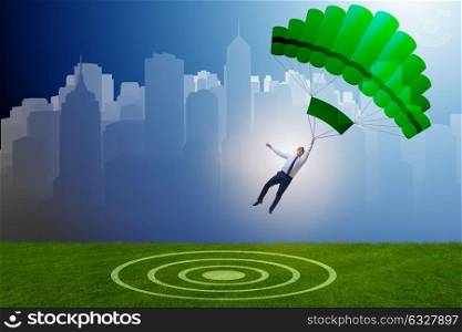 Young businessman falling on parachute in business concept. The young businessman falling on parachute in business concept