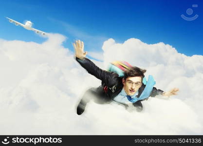 Young businessman flying with parachute on back. Conceptual image of young businessman flying with parachute on back