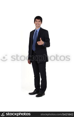Young businessman giving thumbs-up gesture