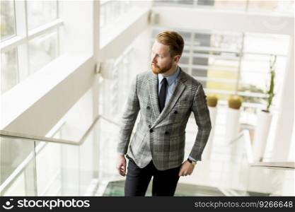 Young businessman going up the stairs in the office building
