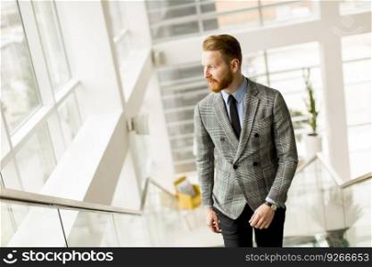 Young businessman going up the stairs in the office building