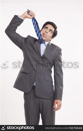 Young businessman hanging himself with tie against white background