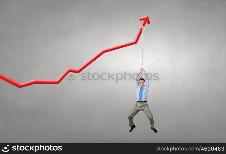 Young businessman hanging on increasing red graph. Growing graph