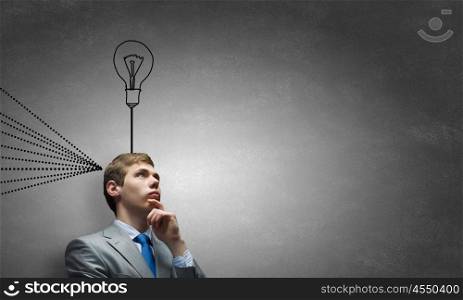 Young businessman has an idea. Young thoughtful guy and ideas coming out of his head