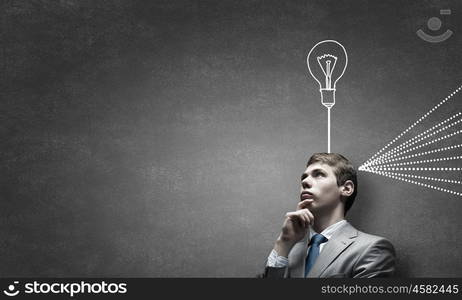 Young businessman has an idea. Young thoughtful guy and ideas coming out of his head