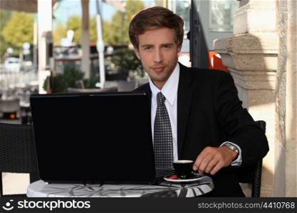 Young businessman having coffee outdoors
