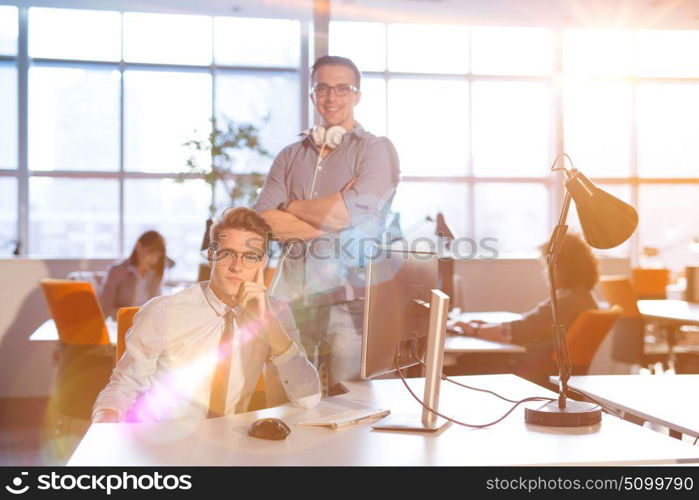 Young businessman helping his colleague to fix the problem at the work