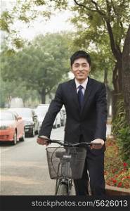 Young businessman holding a bicycle on a city street in Beijing