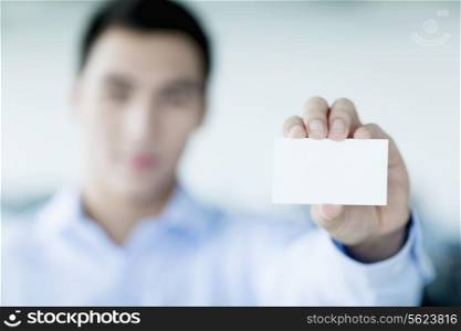 Young businessman holding business card to the camera
