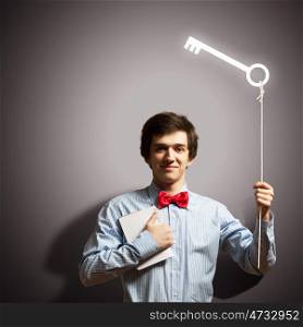 Young businessman holding key. Image of young handsome businessman holding key