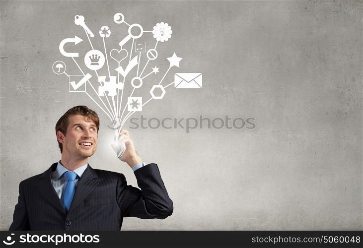 Young businessman holding mobile phone representing e-commerce concept. Modern phone business