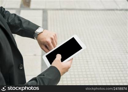 young businessman holding smartphone checking time wristwatch