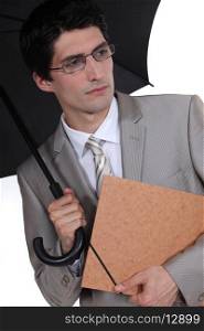 young businessman holding umbrella