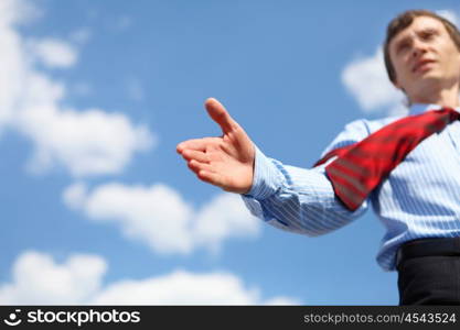 young businessman in a blue shirt and red tie giving a hand for a handshake