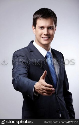 Young businessman in a suit holds out his hand for a handshake