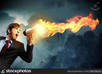 young businessman in black suit screaming into megaphone