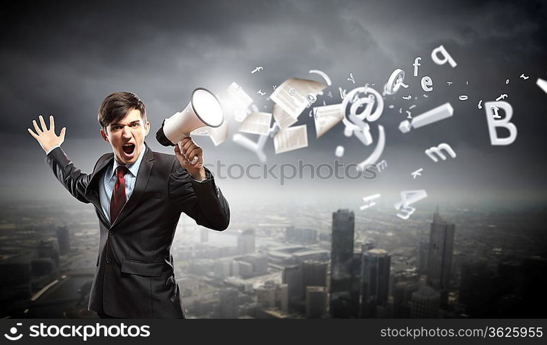 young businessman in black suit screaming into megaphone