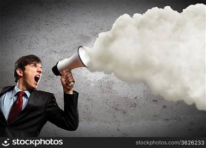 young businessman in black suit screaming into megaphone