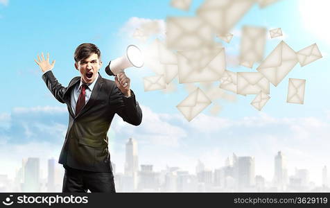 young businessman in black suit screaming into megaphone