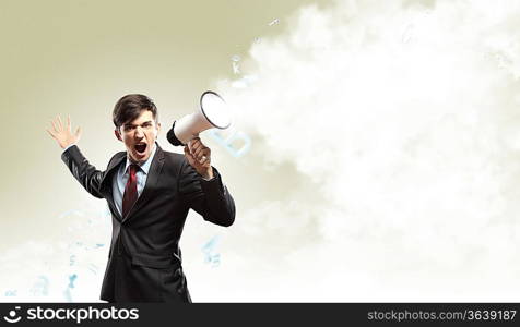 young businessman in black suit screaming into megaphone