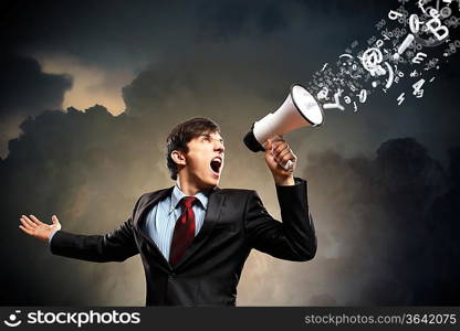 young businessman in black suit screaming into megaphone