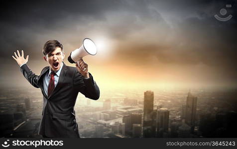 young businessman in black suit screaming into megaphone