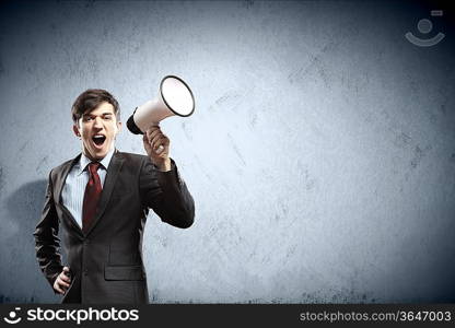 young businessman in black suit screaming into megaphone