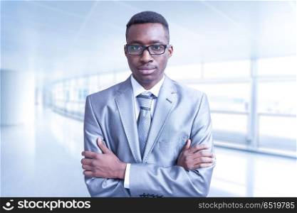 Young businessman in his office. Portrait of young junior businessman in front of his big modern office