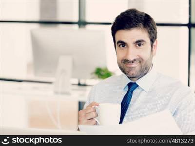 Young businessman in office holding a mug