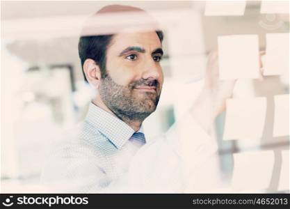 Young businessman in office looking at the notes