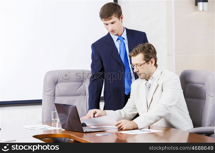 Young businessman in office showing documents to his boss