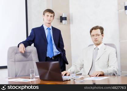 Young businessman in office showing documents to his boss