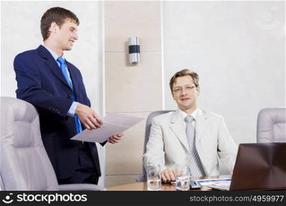 Young businessman in office showing documents to his boss. I&rsquo;ve prepared report